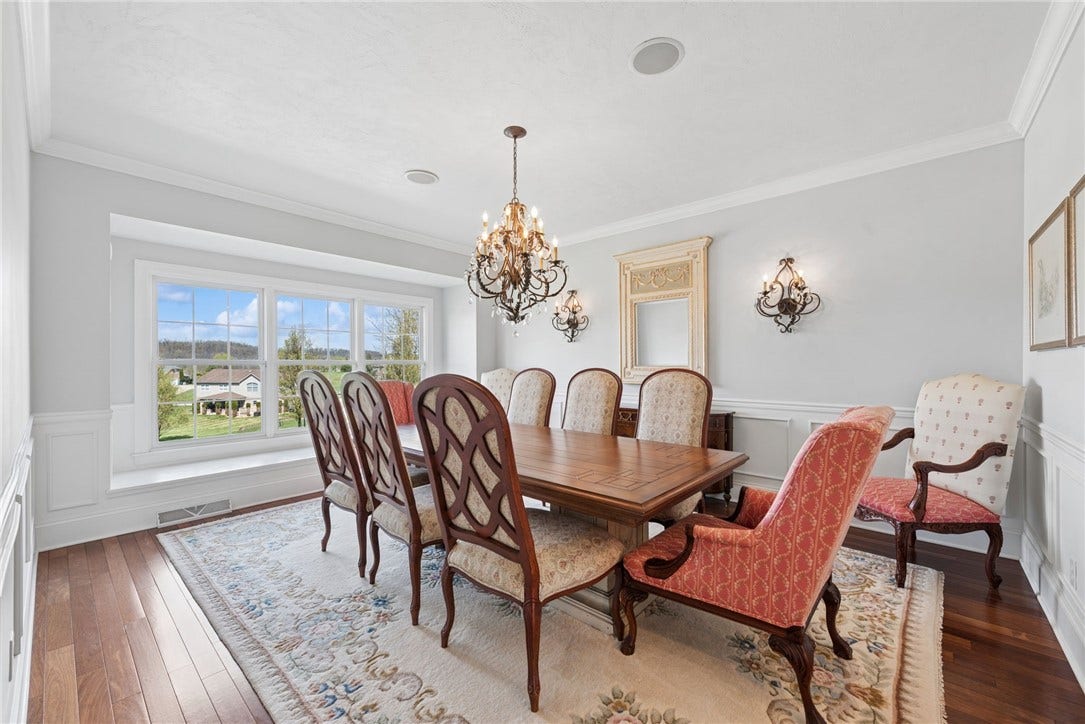 Dining Room with hard wood flooring, crown molding and a window seat
