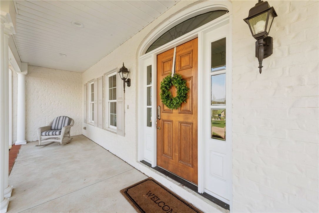 Covered front patio that wraps around to the side and the rear of the home