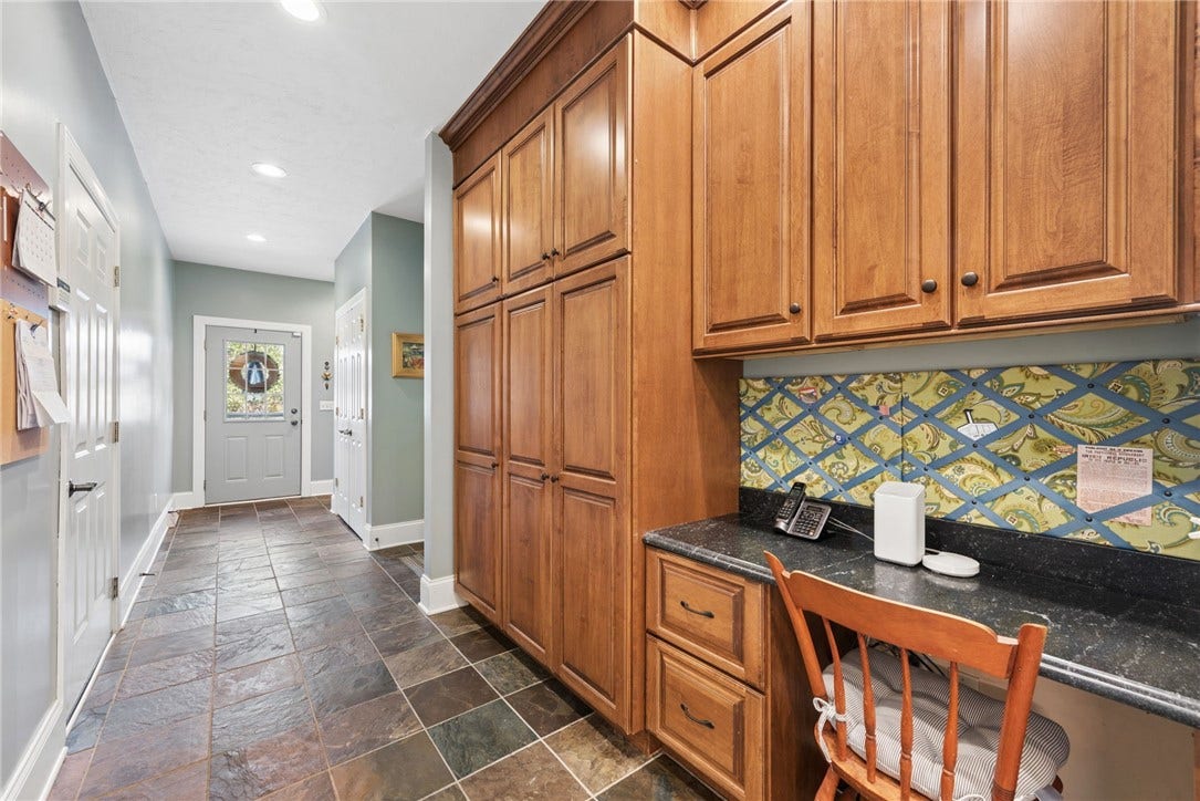 mud room with radiant heated flooring, an abundance of storage and small desk. this leads to the 3 garages