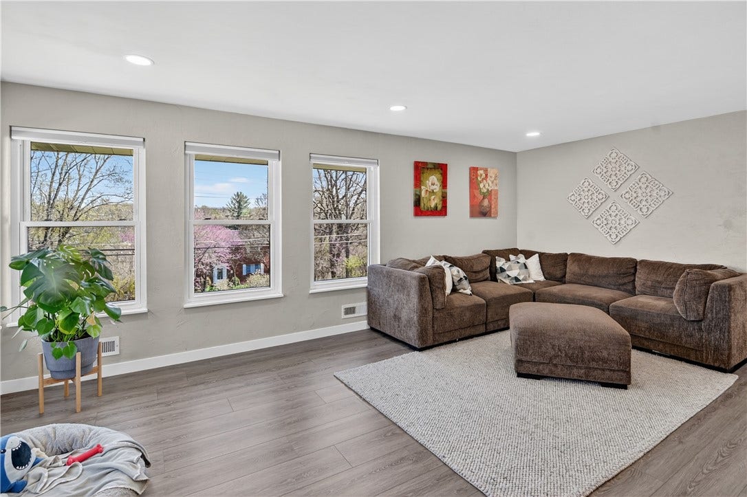 Another view of the living room with windows that face the front of the property.