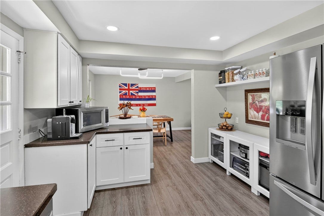 A view from the kitchen into the dining space that captures the added storage beside the refrigerator
