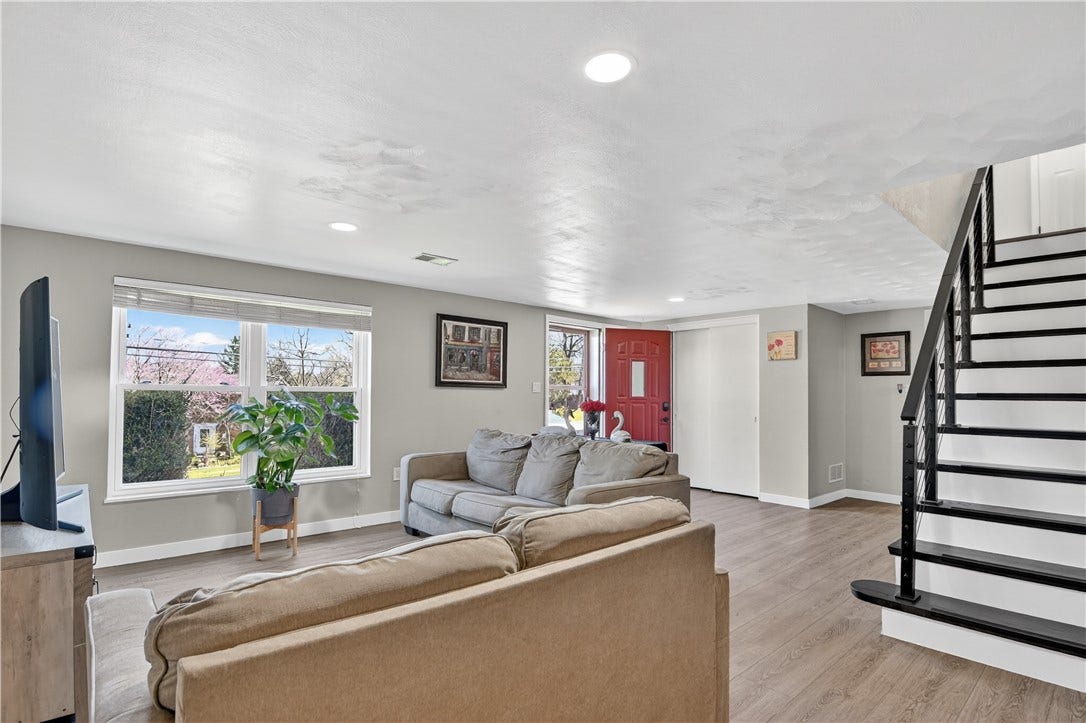 Family room with a view of the exterior front and entry into the LL and stairs leading to the first floor living space.