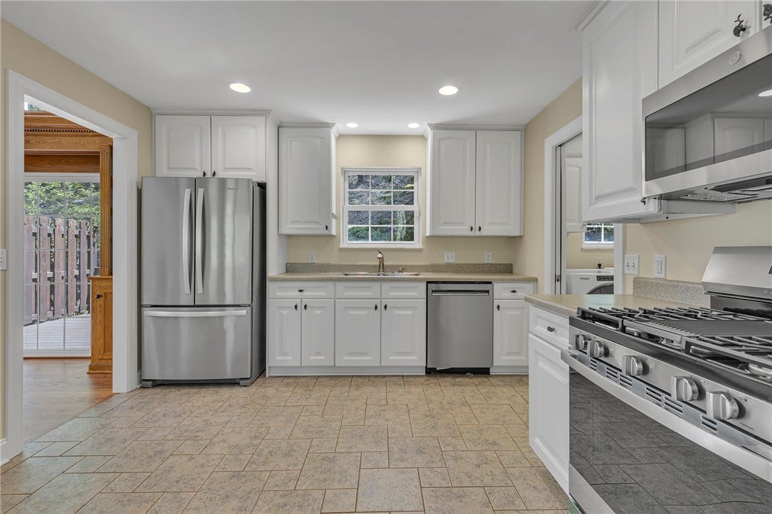 New gas stove and microwave complement the stainless steel appliances in the kitchen.