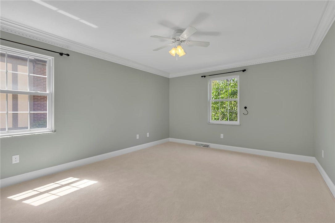 Freshly painted, new carpet and crown molding compliment the first-floor primary suite.