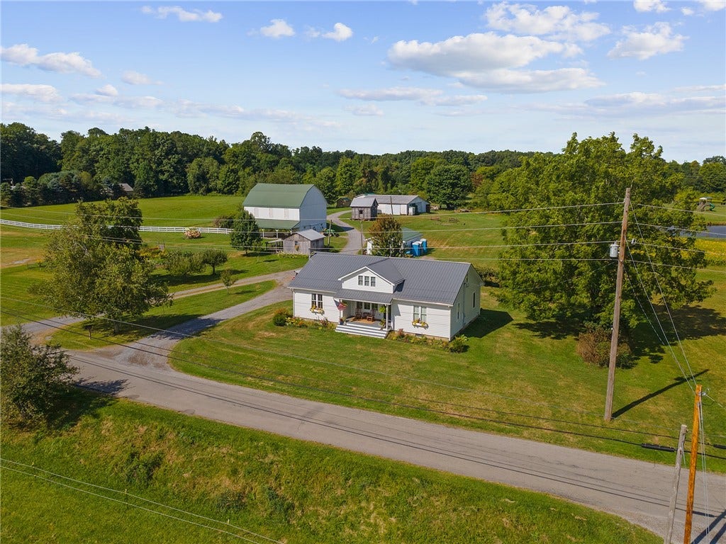 A classic farmhouse setting surrounded by barns, open fields, and peaceful country views.