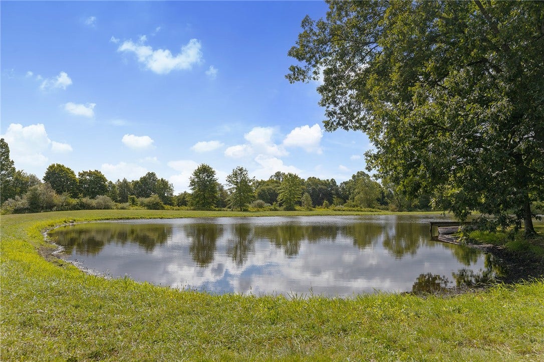 A picturesque pond creates a stunning focal point across the rolling acreage.
