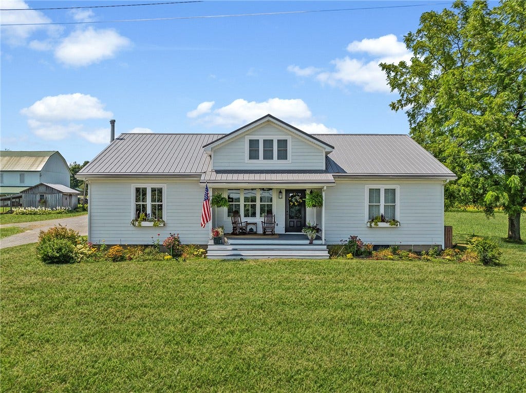 A classic farmhouse setting surrounded by barns, open fields, and peaceful country views.