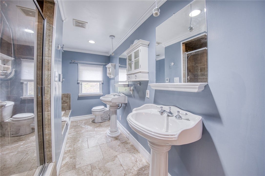 Bathroom with tub, shower, and dual sinks