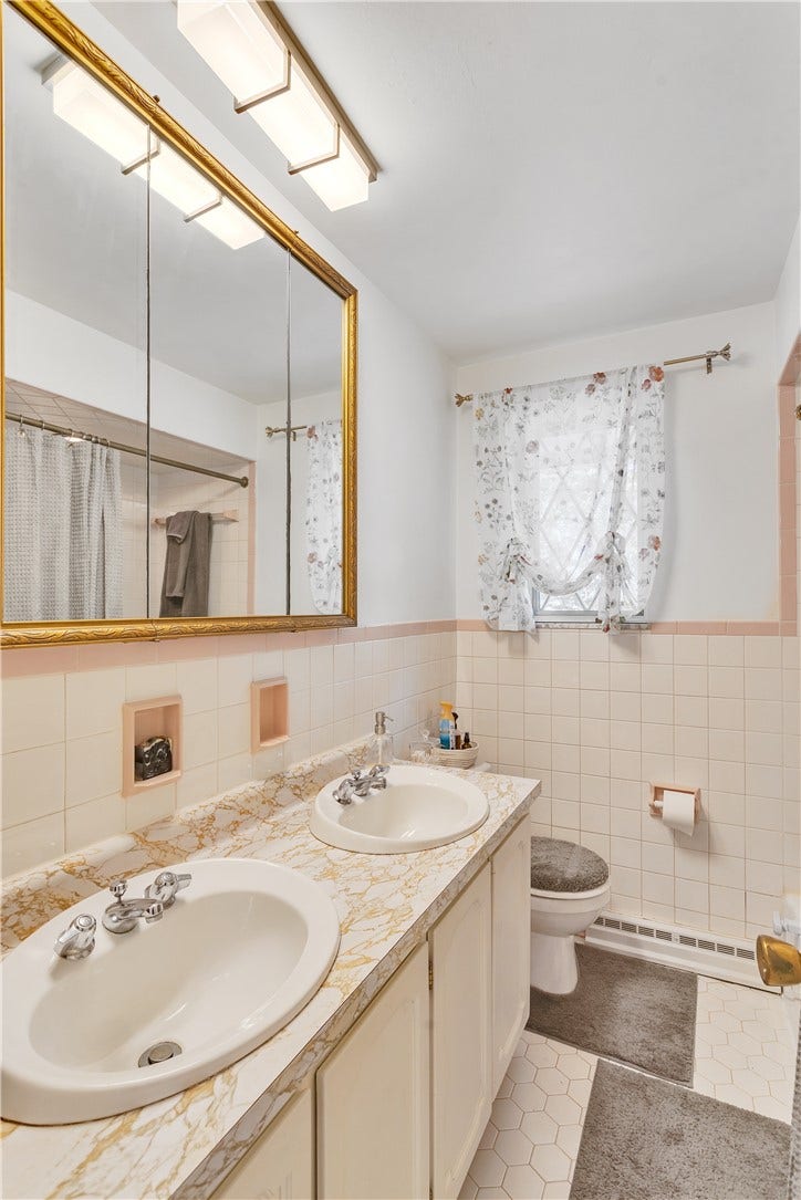 Full Bath on Main Level with Retro Hexagon Tile Floor, Tile Walls and Tub Surround, and Double Bowl Vanity.