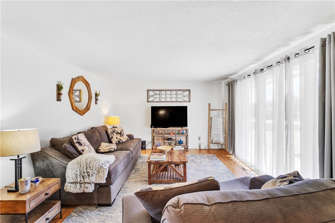 Neutral Paint, Engineered Wood Floors, and Large Windows Pouring in Natural Light.