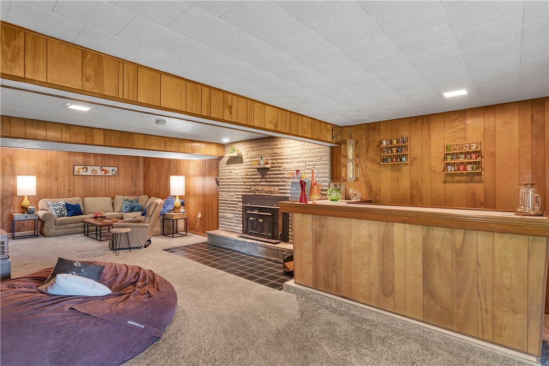 Original Wood Walls and Retro Dry Bar with Vintage Light. Gorgeous Tile Work in Front of the Wood Burning Stove.