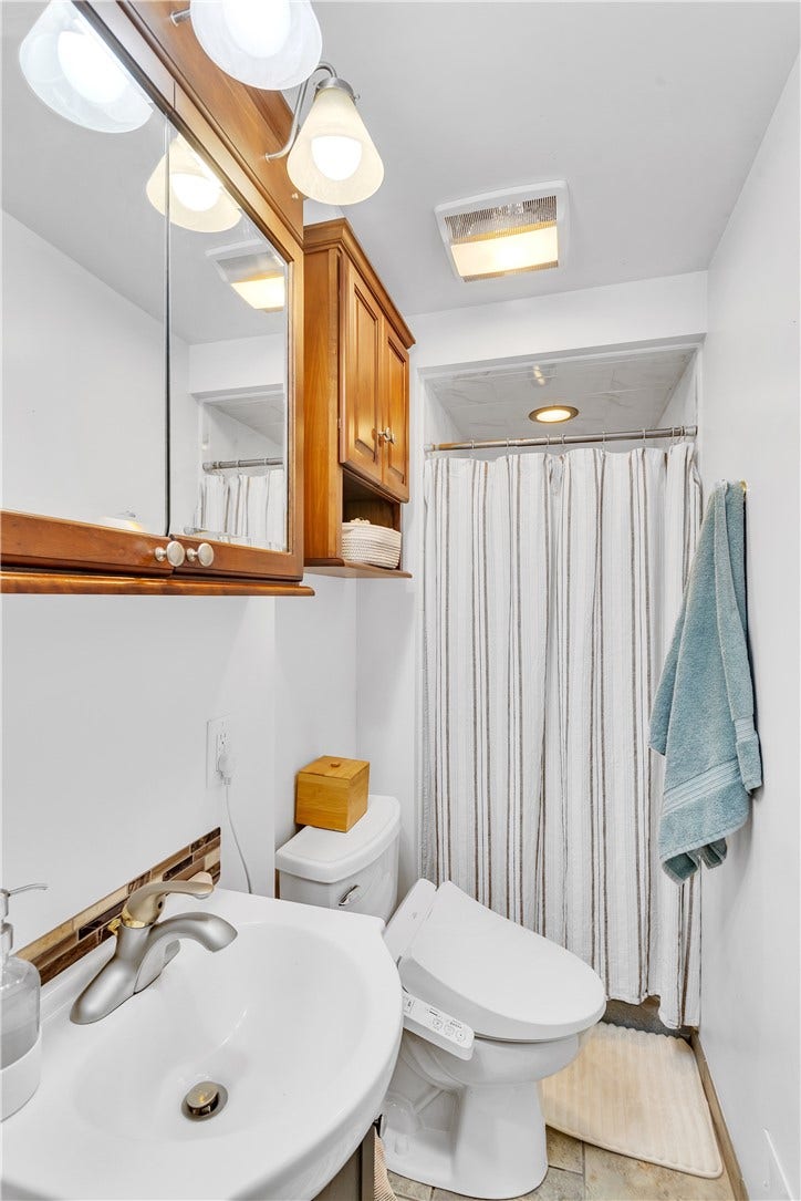 Full Bath with Pocket Door Entry, Tile Floor, and Tile Shower.