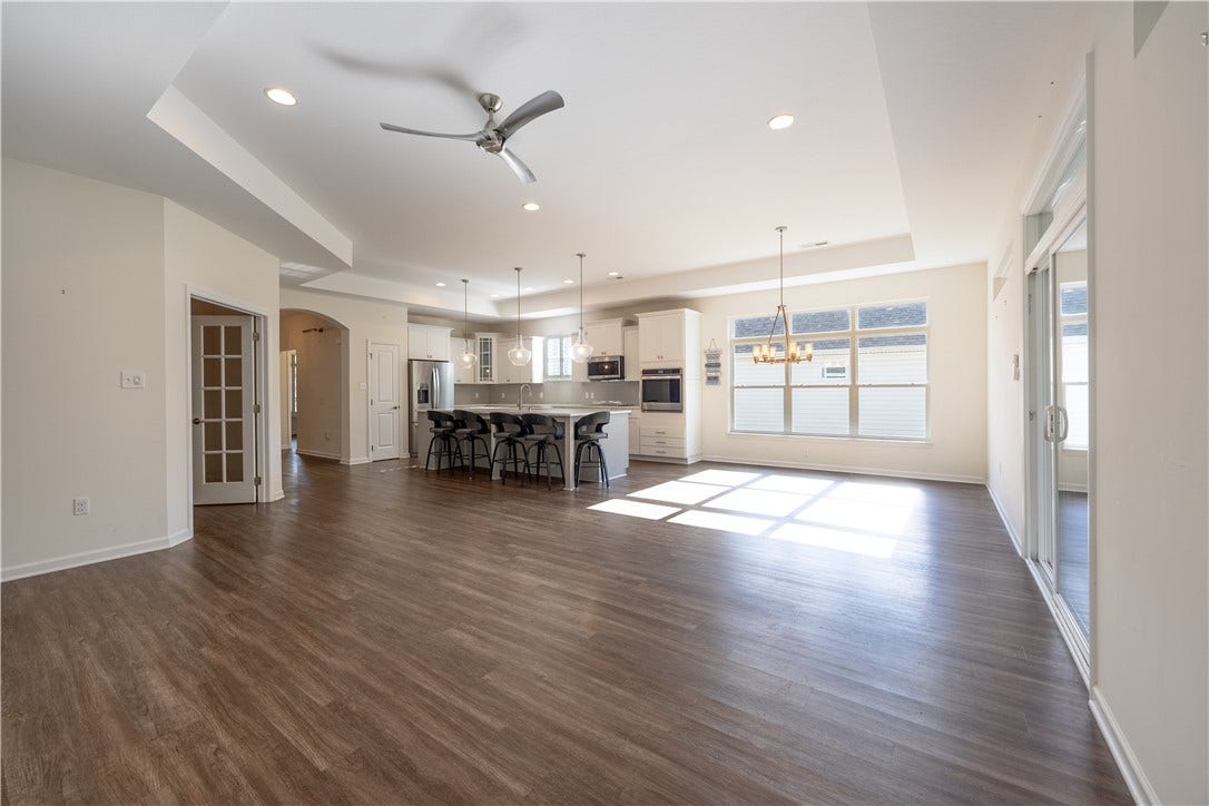 Another view of living space with office or additional room to the left