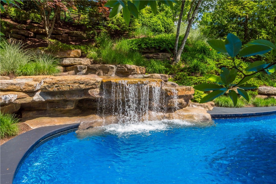 The pool and garden design is consistent with the natural setting.