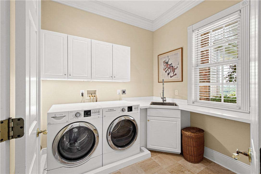 This main floor laundry offers such convenience. New travertine flooring, stainless work sink and new counters create an attractive space!