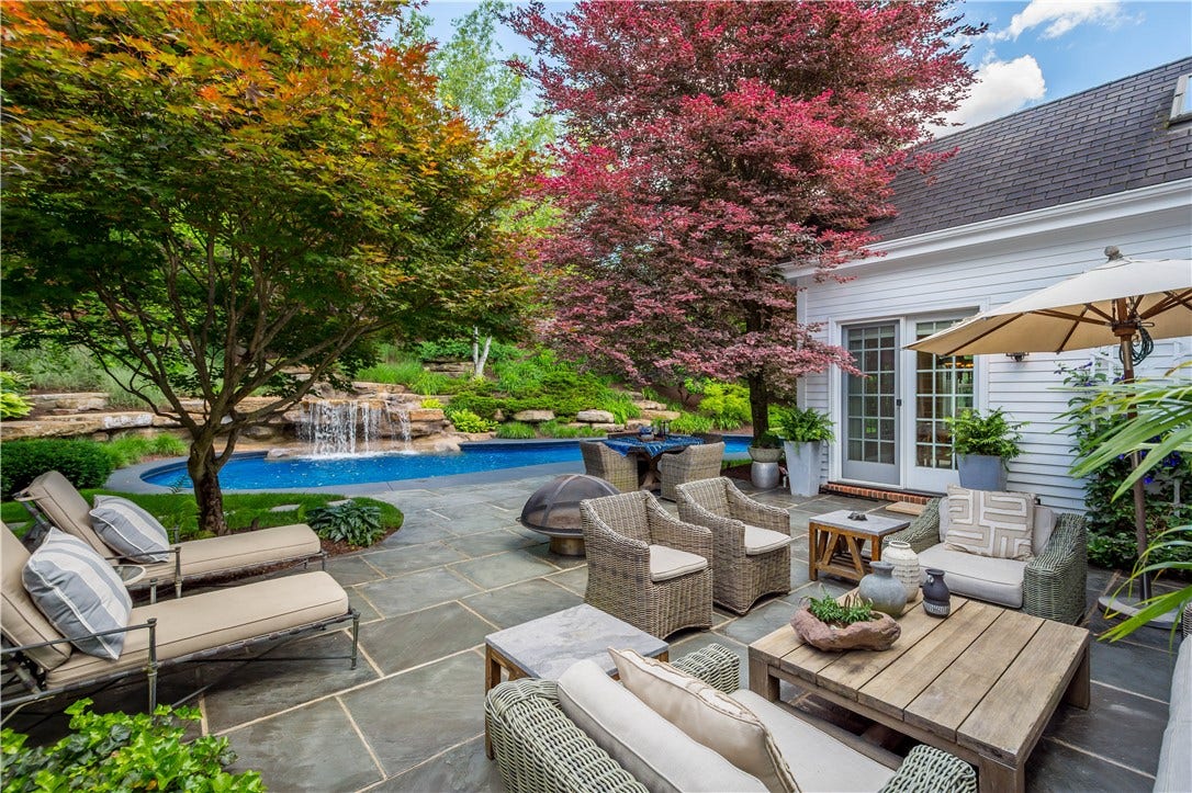 The inviting slate patio is flanked by specimen trees creating a tranquil setting.