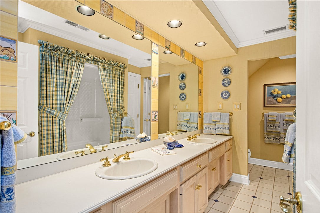 Large bathroom with double sinks can be accessed both from the adjoining bedroom and the hallway.