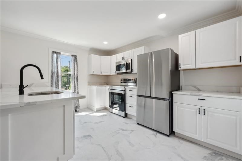 Kitchen view featuring new cabinets, counters and flooring.