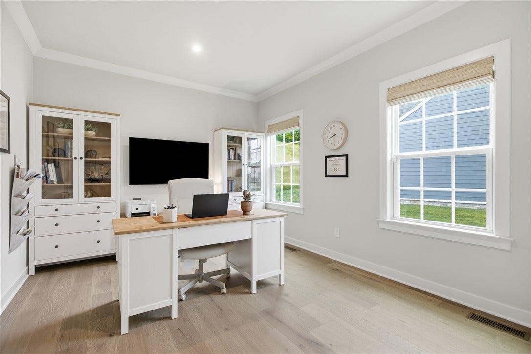 Private main-level office with oversized windows, abundant natural light, and flexible work-from-home space.