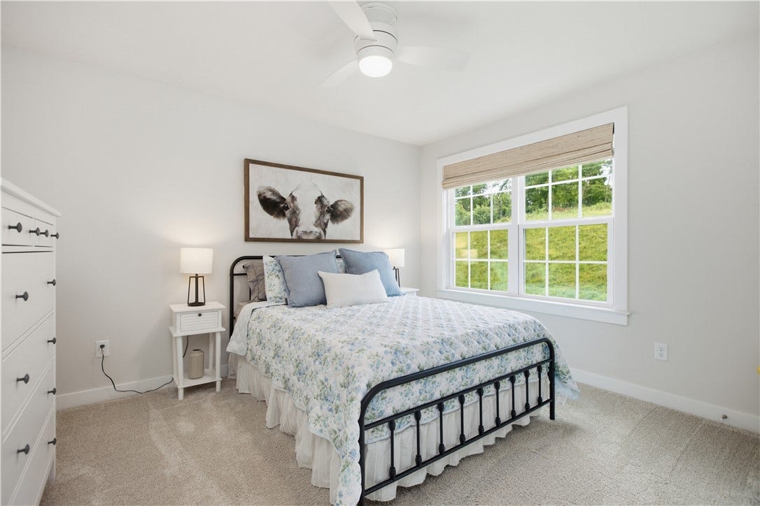 First of three additional bedrooms each with oversized windows, plush carpeting, ceiling fan, and abundant natural light.