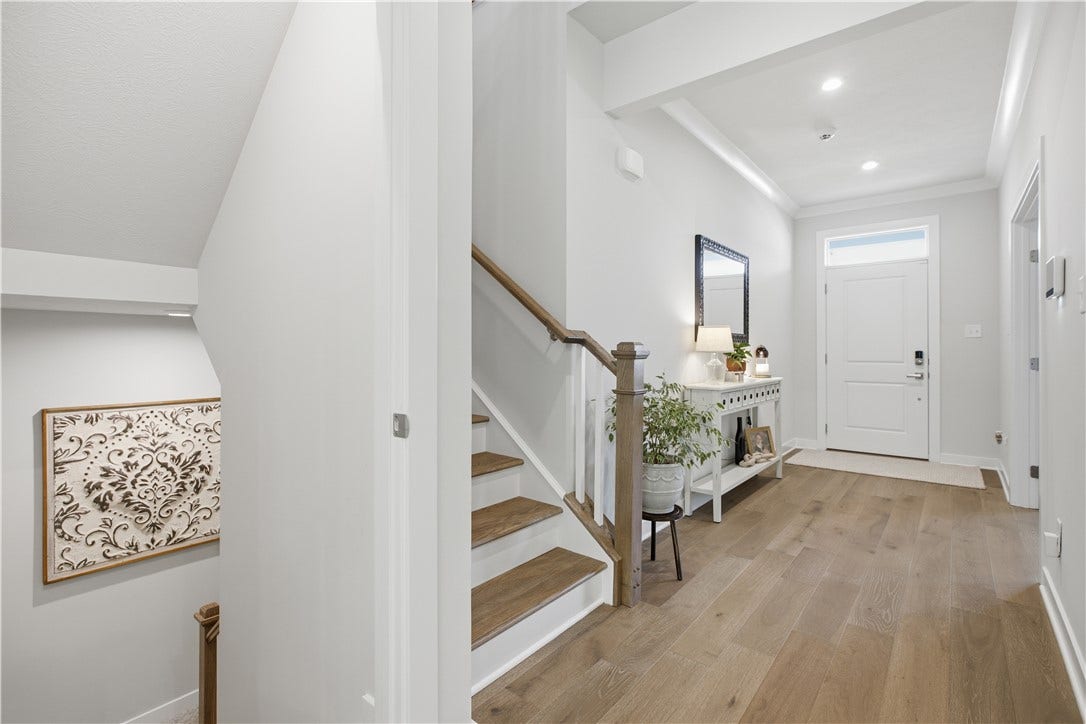 Expansive entry showcases wide hallway, elegant staircase, and recessed lighting.