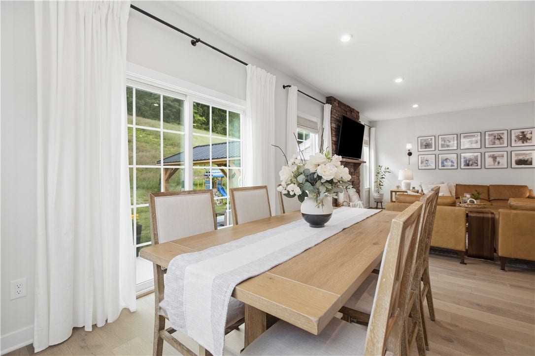 Bright dining area with oversized windows, backyard views, and seamless flow to the backyard and main level living spaces.