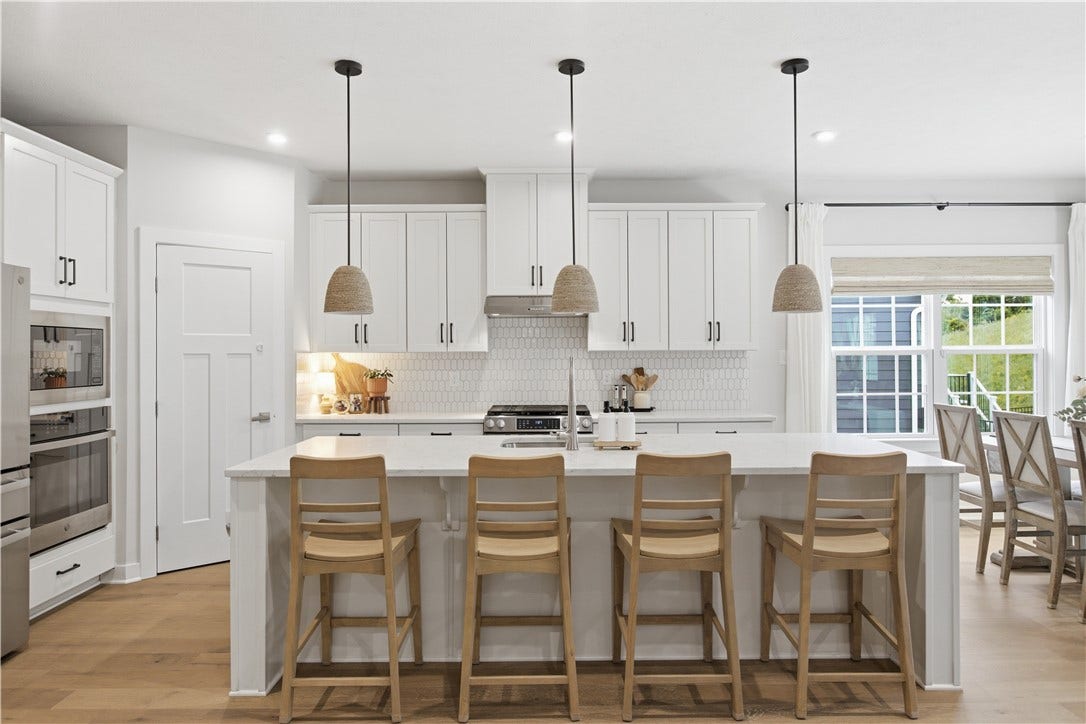 Spacious center island comfortably seats four, offering generous prep space and casual everyday dining.