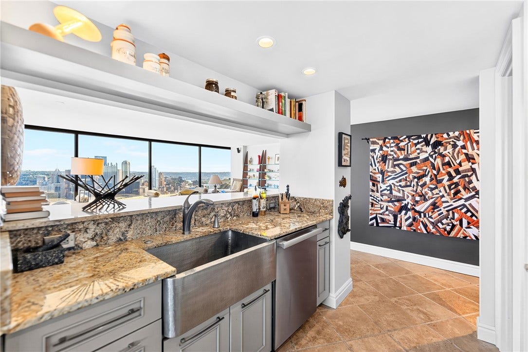 1 Trimont Ln, #490E, Pittsburgh, PA 15211 Sink/serving side looking into the living area:
Even the Kitchen enjoys the view! Farmhouse sink, granite counters & pass-through opening connect the Kitchen to the expansive living spaces and Pittsburgh skyline.