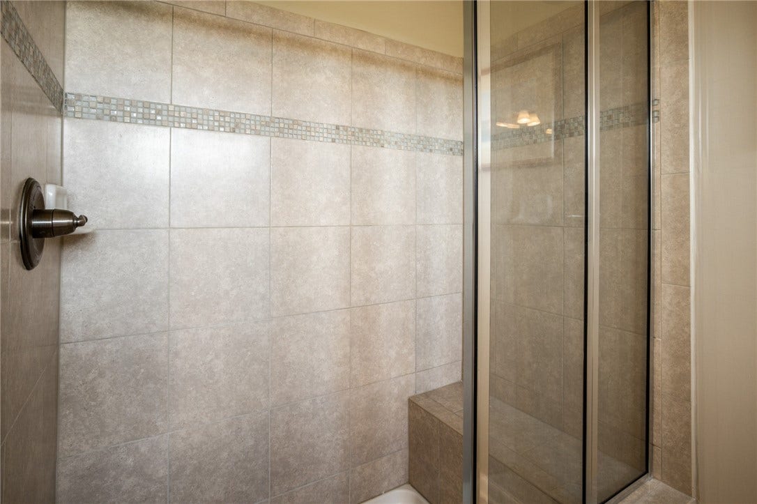 Ceramic tile walk in shower with seat.