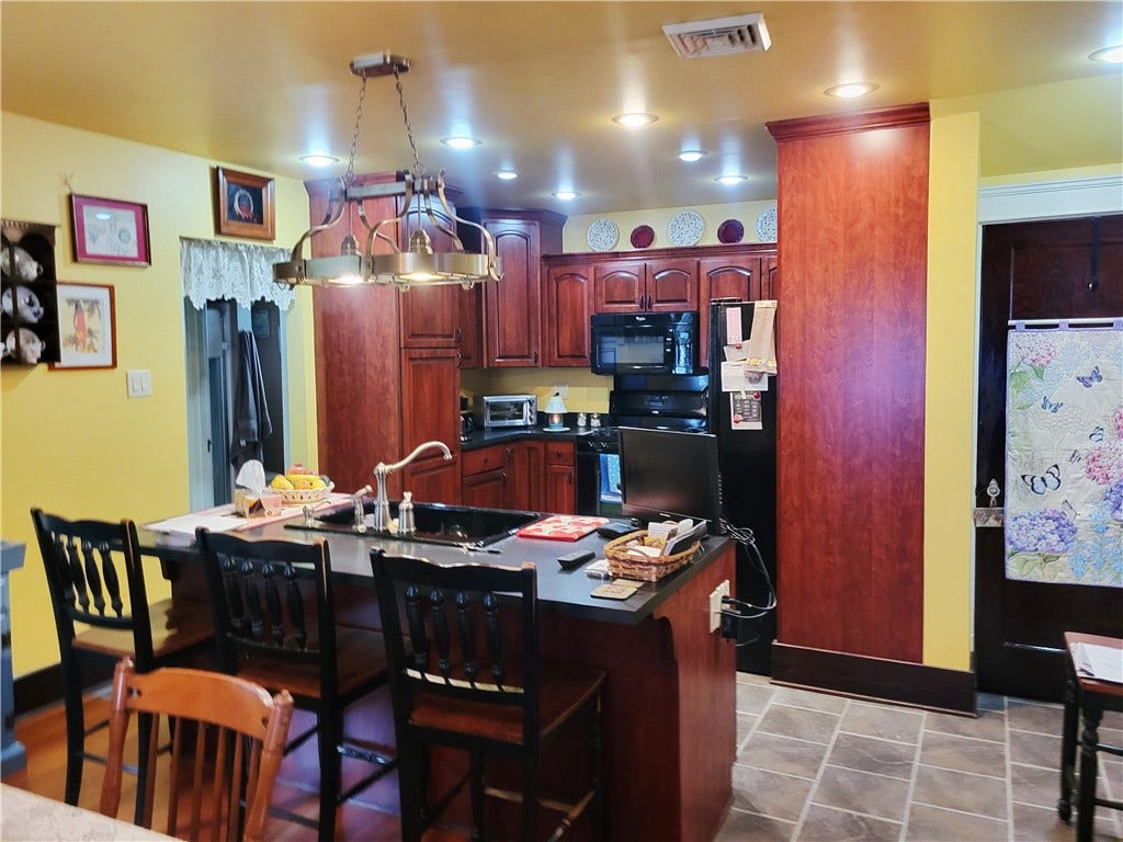 Kitchen island and kitchen with ceramic floors.