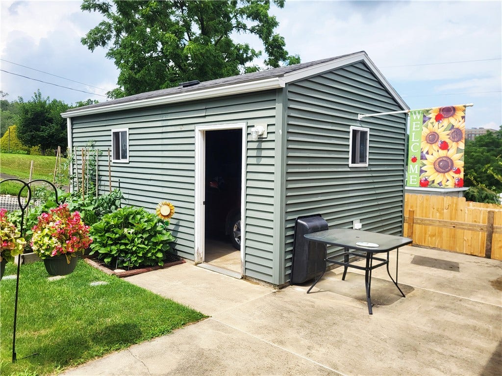 One car detached garage with concrete patio.