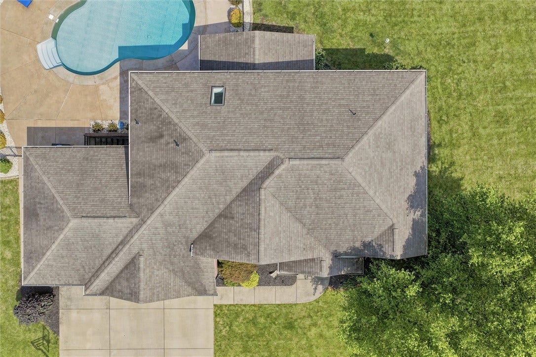 Hip Style Roof, Concrete Driveway, and Completely Level Lot.