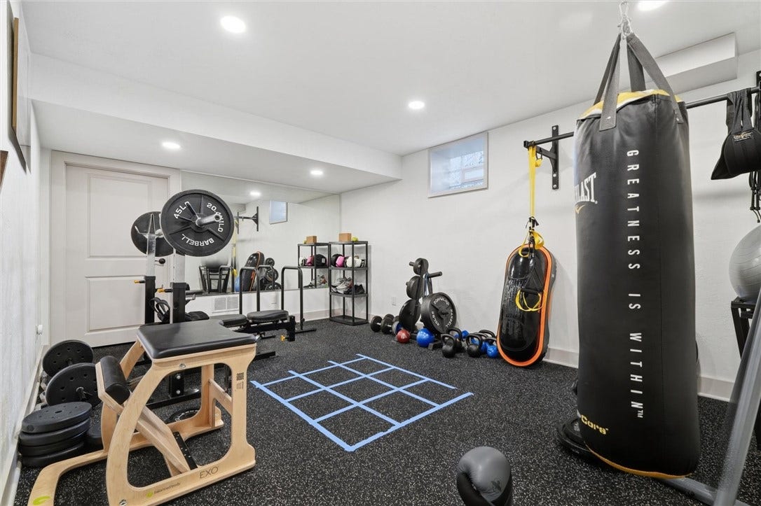 18x12 Home Gym Area with Mirrored Wall, Vented Glass Block Window, and Door to 18x10 Storage Room at Back.