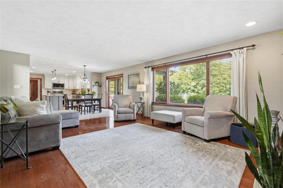 Completely Open to the Kitchen with Large Picture Window Flanked by Casement Windows.