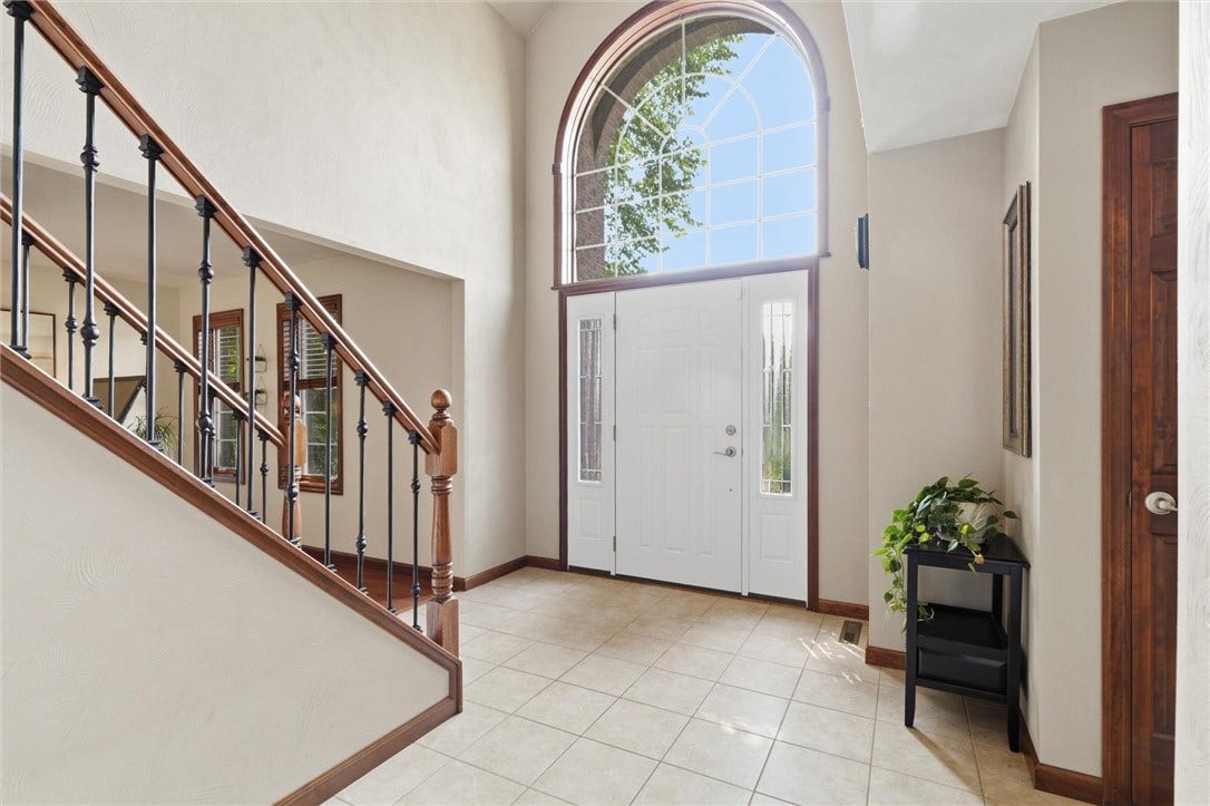 12x10 Tiled Foyer with Soaring Ceiling, Gorgeous Palladian Style Window, and Wood/Iron Railing.