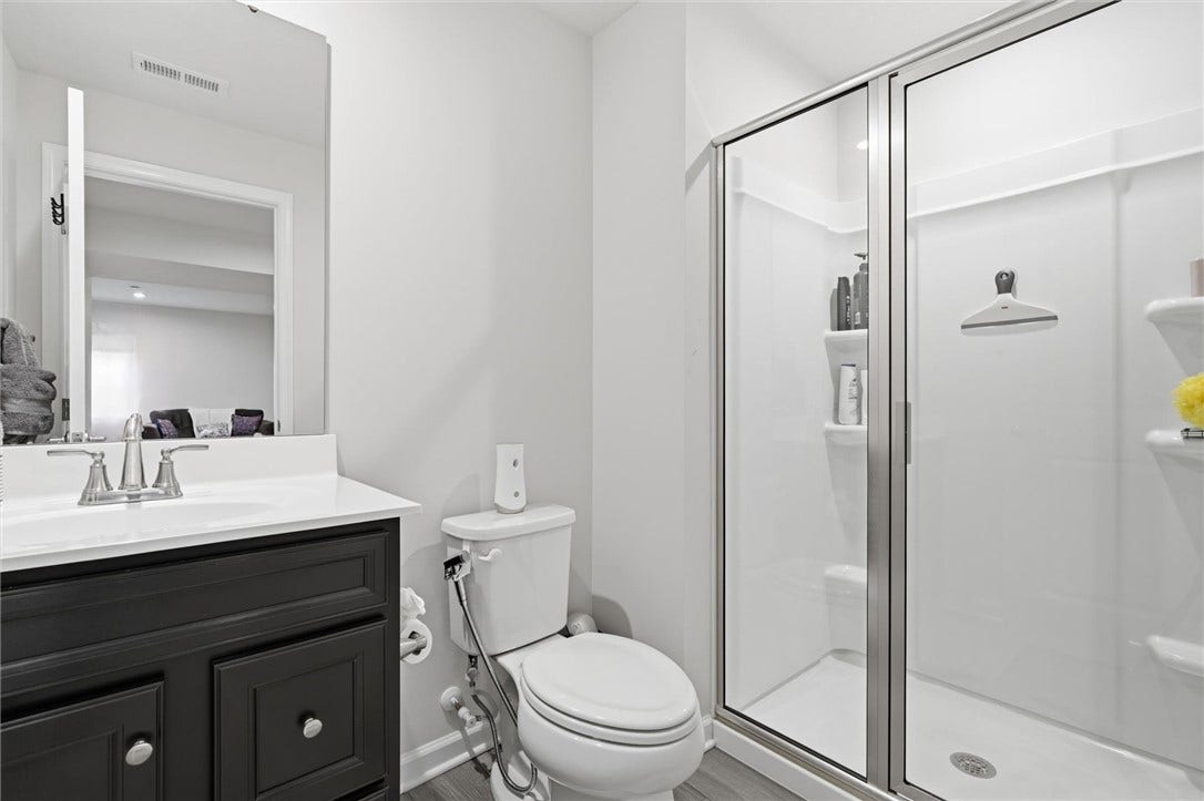 Full Bathroom #3 on Lower Level with walk in shower, molded shelving and glass door.