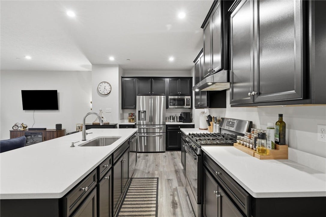 A spacious 19'11' gourmet kitchen showcases an 8.5-foot grand island with seating for four, complete with a dishwasher and touch-activated faucet with sprayer.