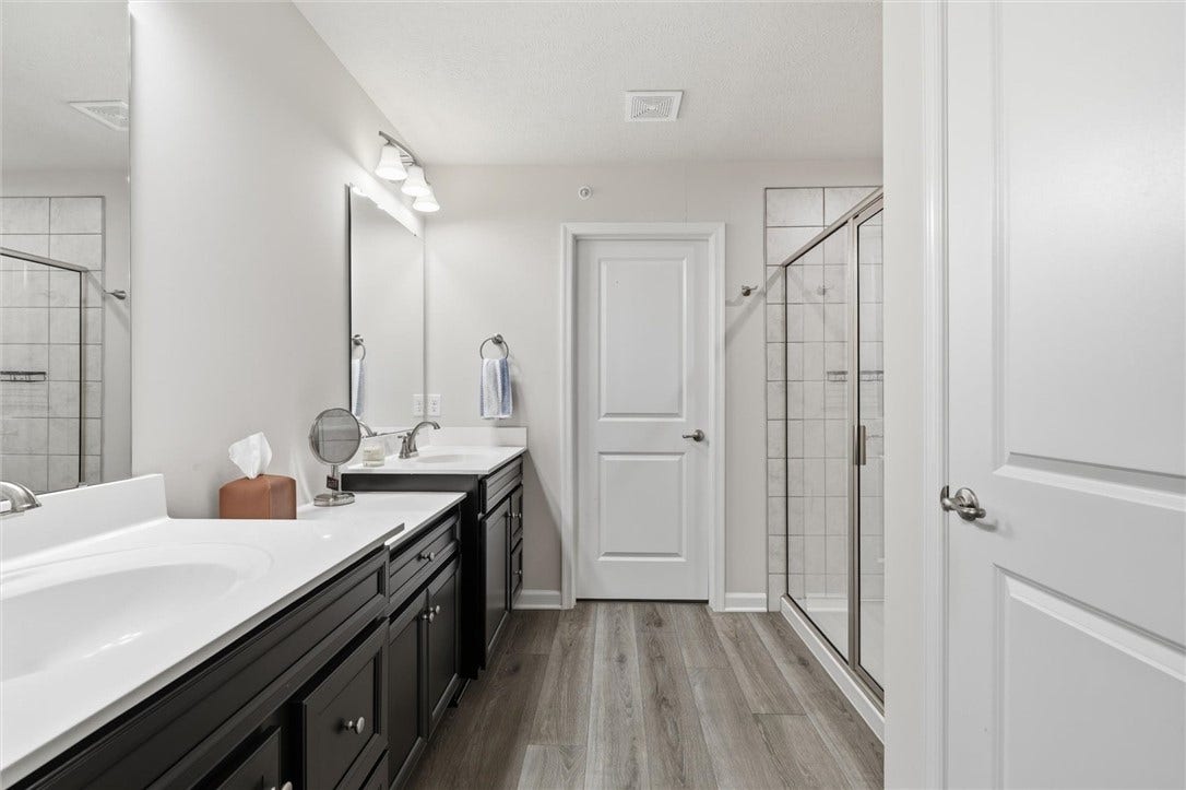 Primary bath with step in shower,  a private potty behind closed doors and large walk in closet measuring 8'x6'.