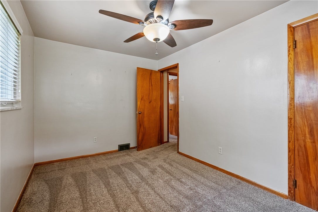 The second bedroom in the front of the house, also hardwood under the carpet