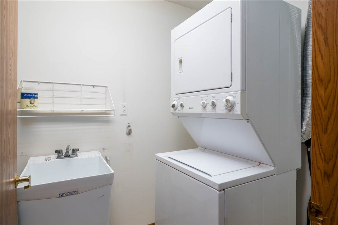 Laundry area with utility tub, hot water tank and furnace.