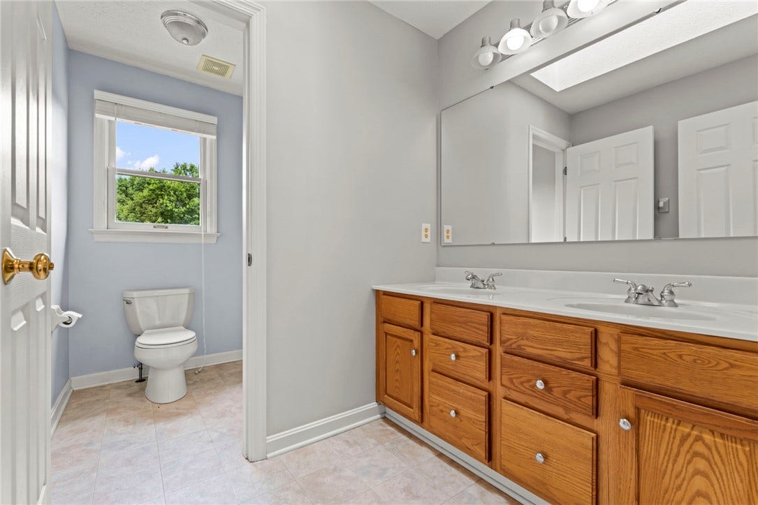 Upper level hall bathroom with double vanity and tub/shower combination.