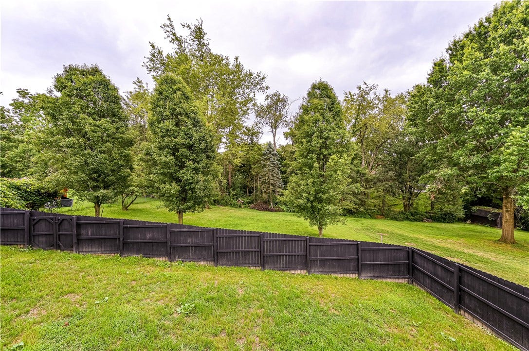 What an awesome back yard! There is a large fenced in area and additional space behind it bordered by trees.