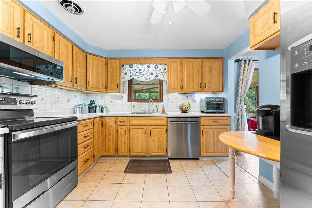 Kitchen features stainless steel appliances including a microwave, electric stove, dishwasher, refrigerator, and disposal; all units are under 5 years old.