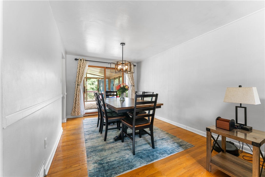 The hardwood floors extend through the dining room which also features a chair rail, lovely chandelier, and a sliding door to the first-floor sunroom. The neutral tones extend to the dining room.