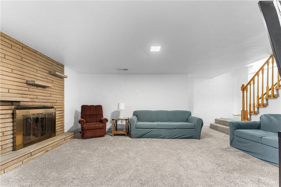 Game Room featuring a stone gas fireplace, under-step storage, and a newer glass block window.