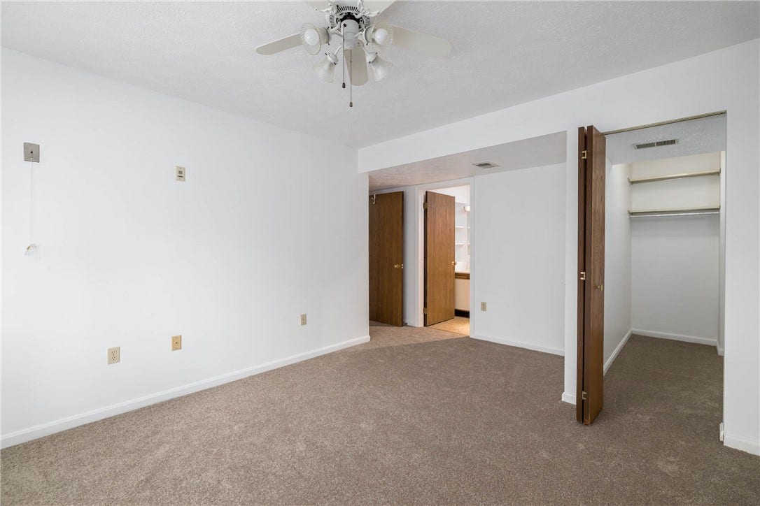 Primary bedroom with view to walk in closet and full bath.