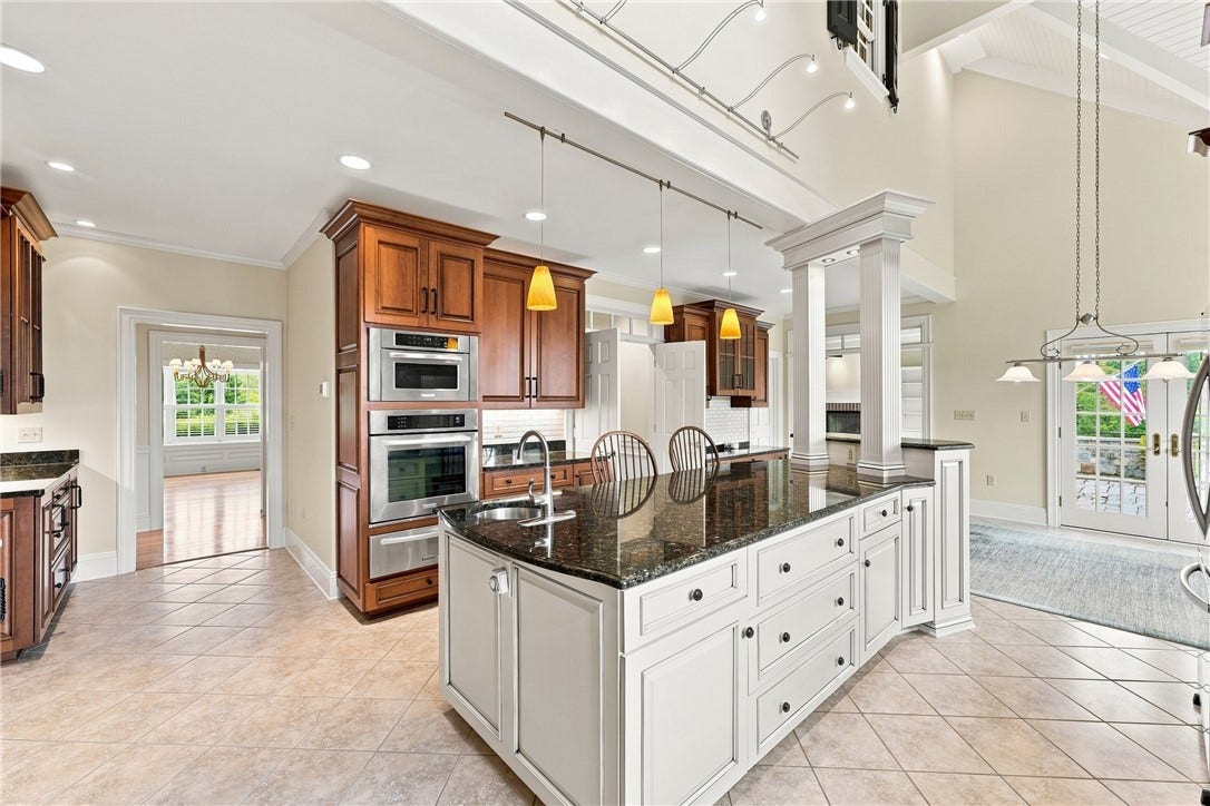 Featuring KitchenAid and Wolf appliances meal prep is a breeze. This kitchen features two ovens, a gas range, and a warming drawer in addition to the microwave, refrigerator, trash compactor and dishwasher.