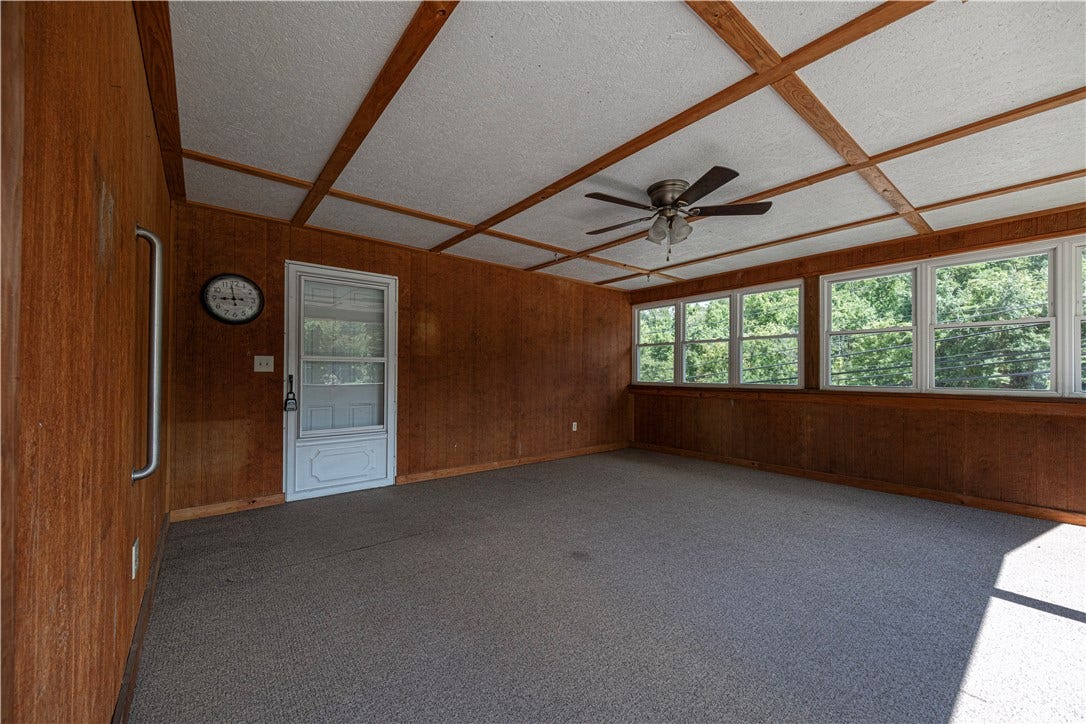The covered  porch measures 16'x17' .  It's carpeted and has a ceiling fan.  There are windows on the front of the porch and the side is open.  There is also a locked door to get onto the porch.