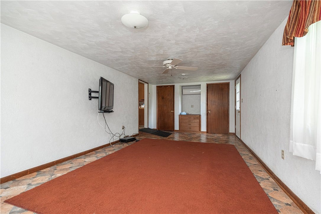 The family room measures 24'7" x 11'4".  There are 2 closets, plenty of windows, and a celling fan.  The door on the right exits to the outside.