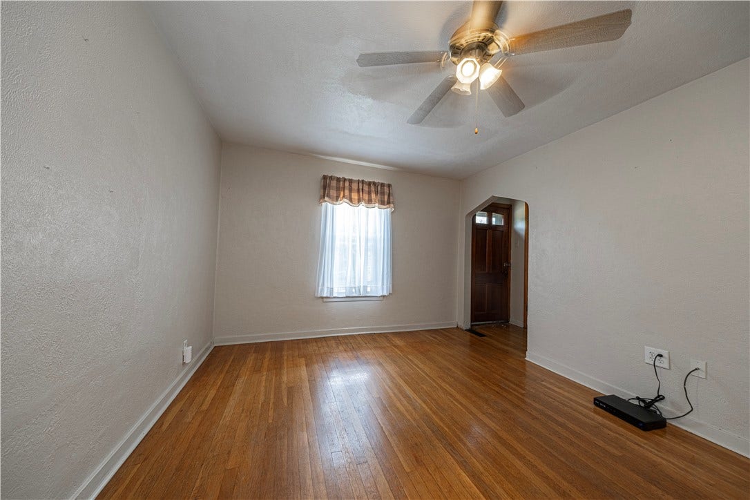 The living room measures 11' x 8'6".  The hardwoods are in excellent condition, and there is a ceiling fan.